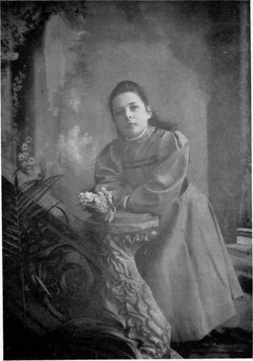 Taken with an ordinary 10 in. cabinet lens at a distance of 10 ft.; compare with Plate II. and note the exaggerated size of the hand, flower, and foreground, and the dwarfing of the background. (By the Author.