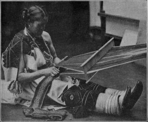 Fig. 43. Indian girl weaving a belt by hand.