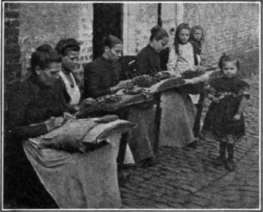 Fig. 59. Lace being made by hand on pillows with tiny bobbins of thread.