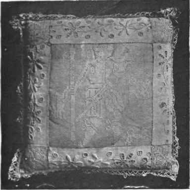 Cushion with fine filet squares, four bands of broderie anglaise and edge of pillow lace