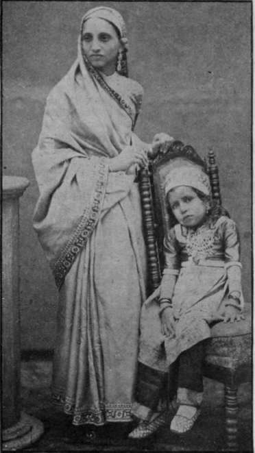 A Parsi mother and child. At a Parsi wedding women and girls wear silks of every colour, with gold and silver embroideries, and many jewels