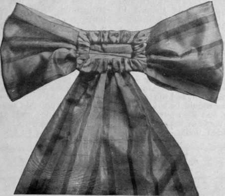 A sash bow with a ribbon covered buckle that can be attached to the back of the dress by means of a safety pin, thus obviating the need of a belt