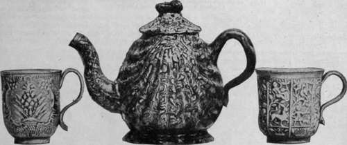 Teapot in mottled, or agate ware, and two cups in salt glaze. Such ware was among the first produced by Wedgwood, and but few specimens can be identified now From the South Kensington Museum