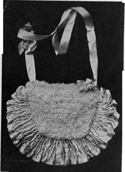 A dainty muff for a child. It is worked in white wool, with a frilled flap, and lined with pale blue satin