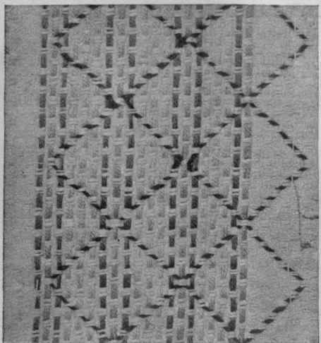 A simple darning pattern for huckaback in green and white. The diamond is indicated by a dark green silk