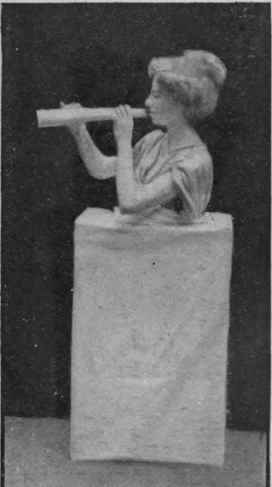 Bust of a flute player. The flute is made of white paper or cardboard