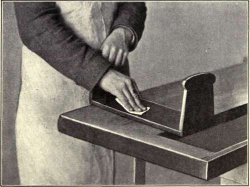 Fig. 99. Method of Grasping Sandpaper in Rubbing Down Shellac Finish.