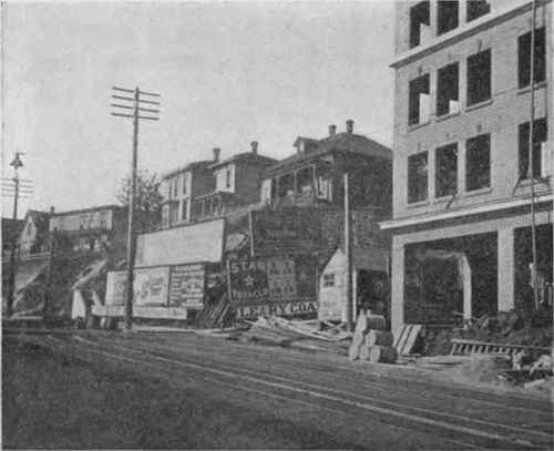 Cost of excavating high bank has made a break in business buildings on traffic street. First floor of new building shown excavated 60 feet back, which upper stories run 120 feet back. First Avenue, Seattle.